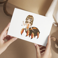 Person holding a card with a spider woman cartoon character 