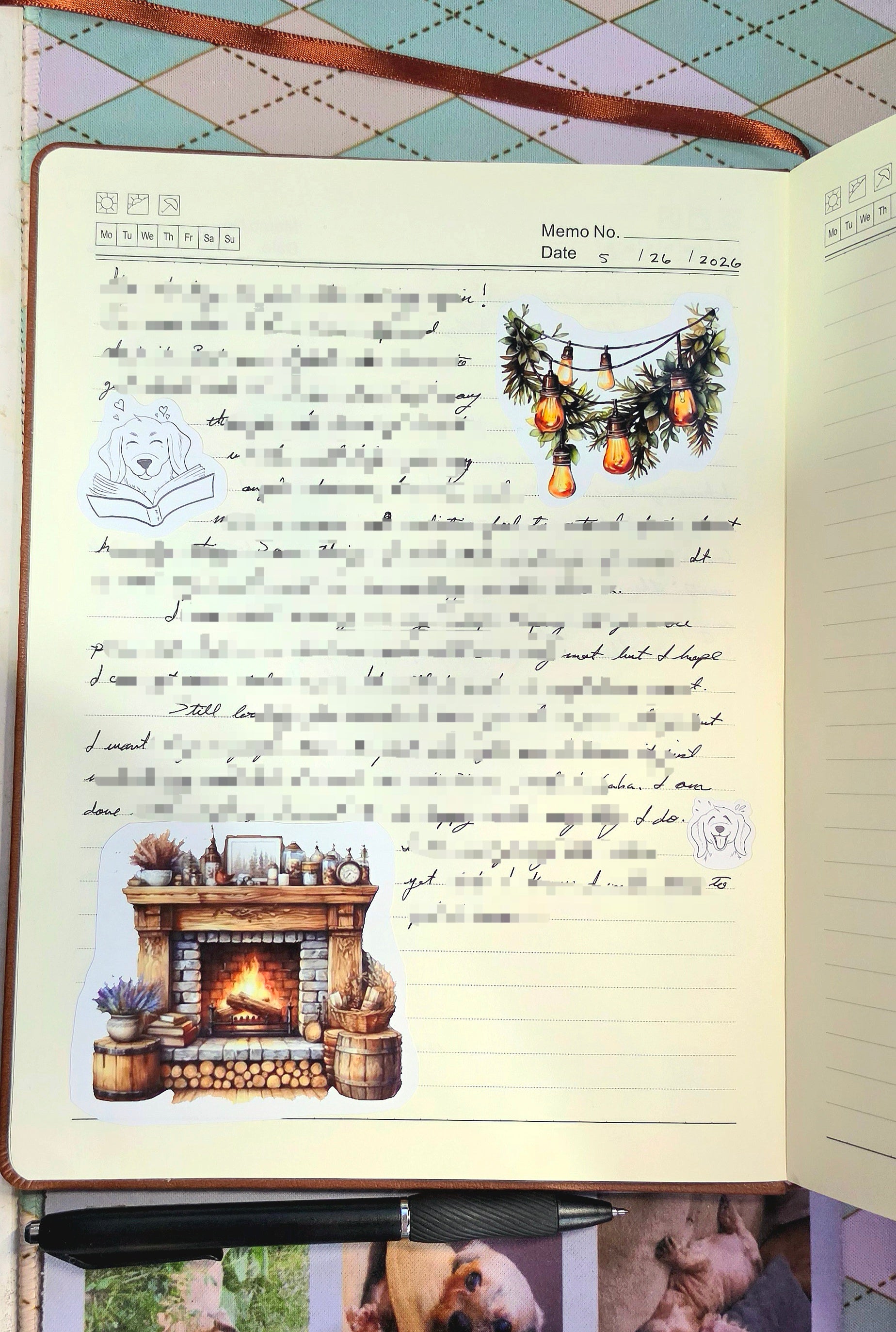 Notebook with decorative stickers featuring a fireplace and Christmas tree on a checkered tablecloth background.