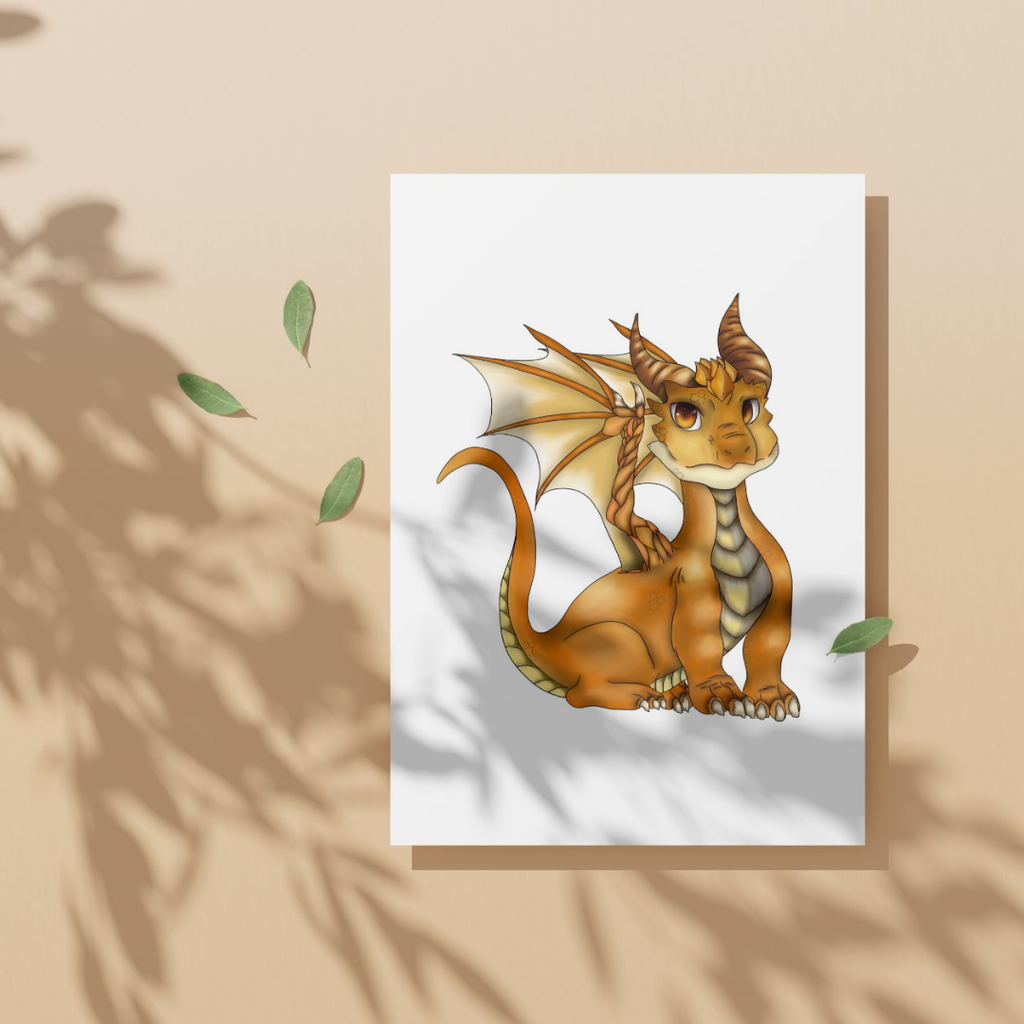 Cartoon dragon illustration on a white card with a beige border, placed on a beige surface with green leaves.