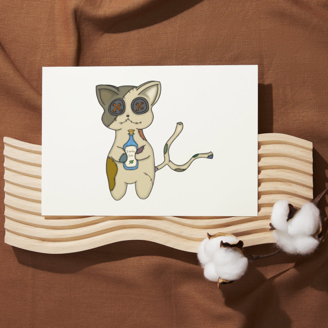 Illustration of a cat-like creature with button eyes and a bottle on a white card, placed on a wooden stand with cotton balls on a brown fabric background.