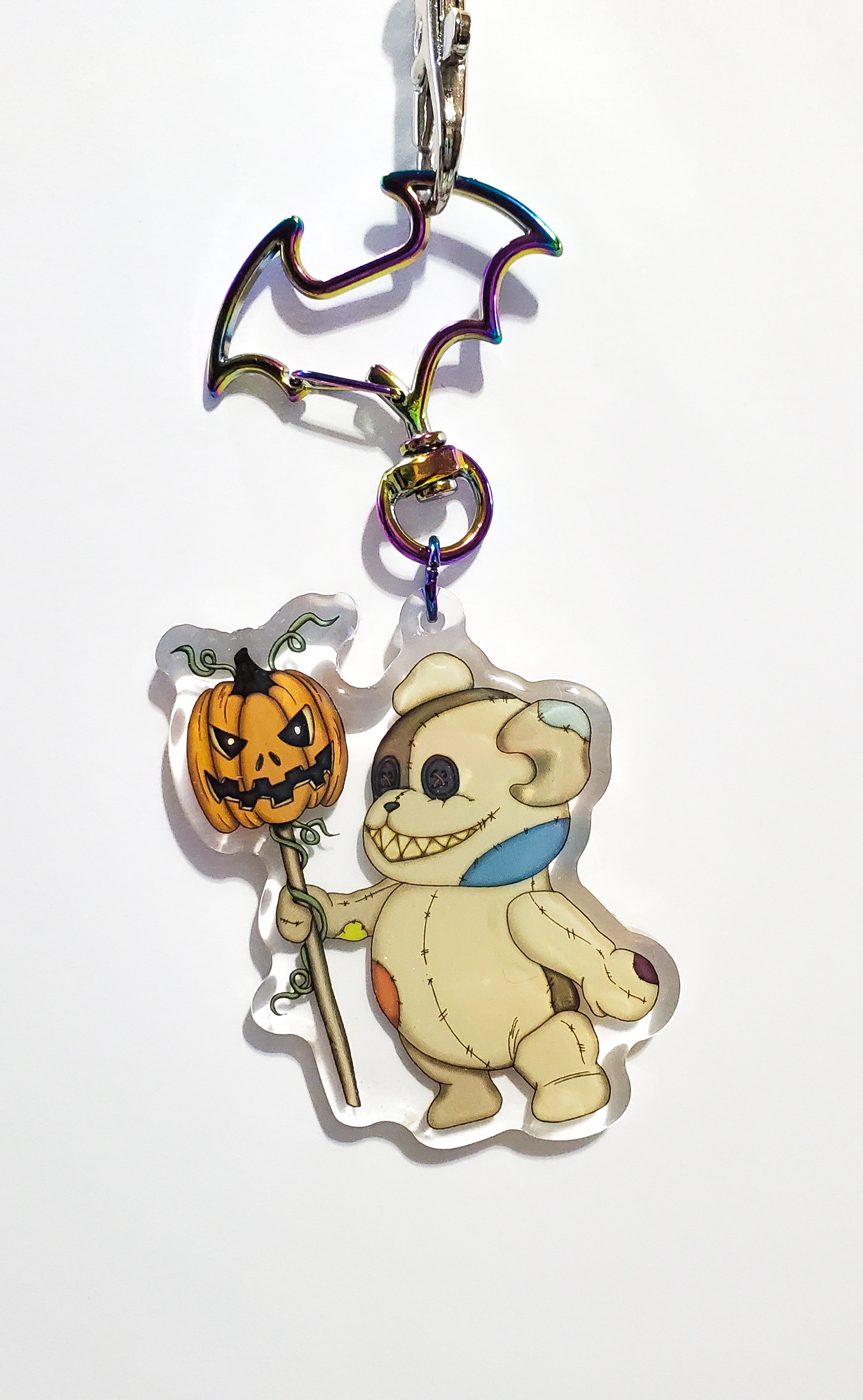 Halloween-themed keychain with teddy bear and pumpkin design on a white background