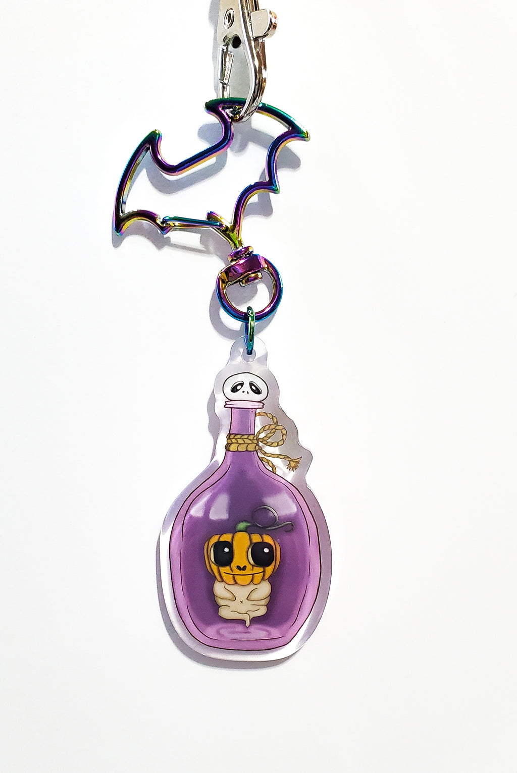 Keychain with a purple bottle and character design on a white background