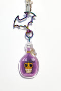 Keychain with a purple bottle and character design on a white background
