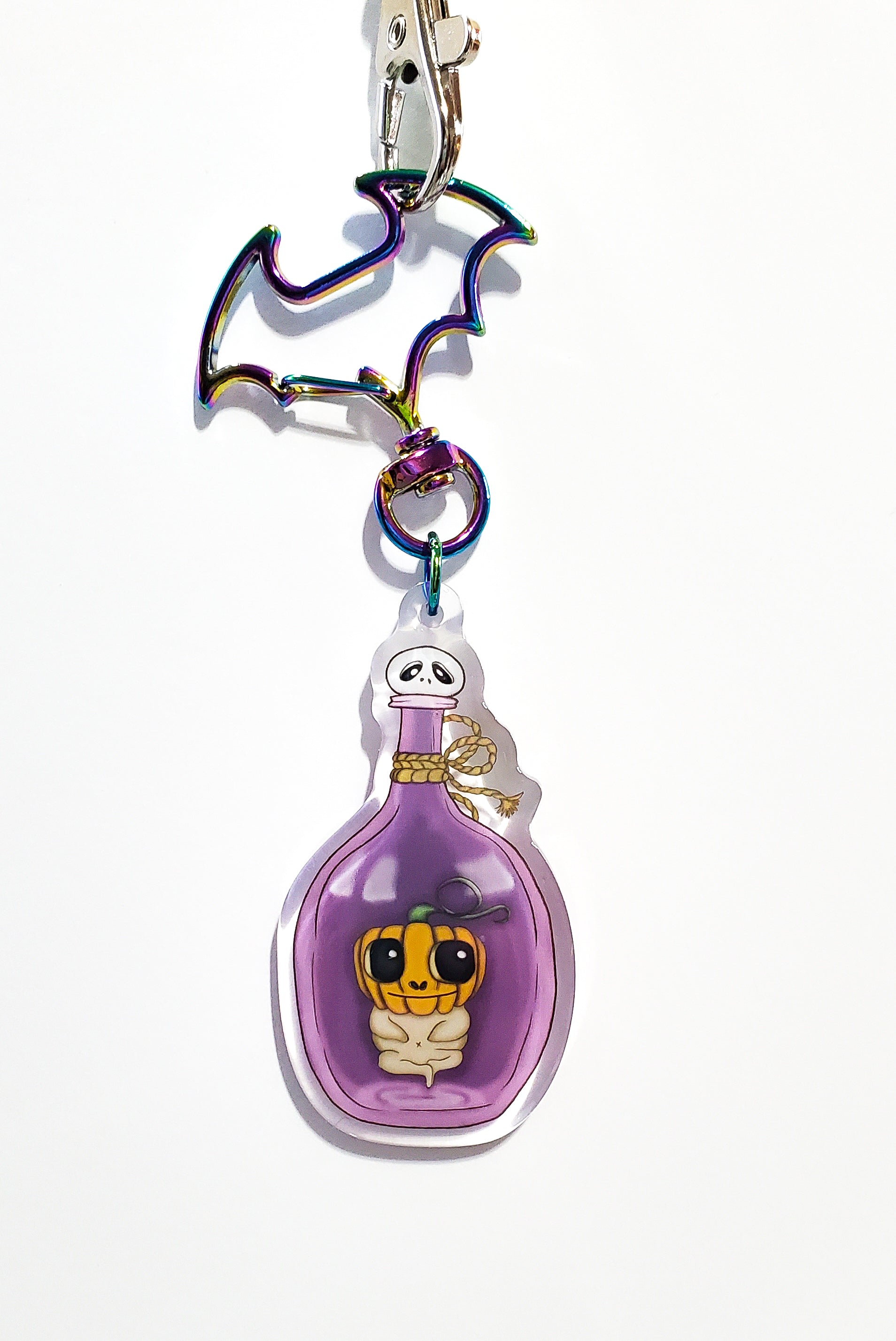 Keychain with a purple bottle and character design on a white background