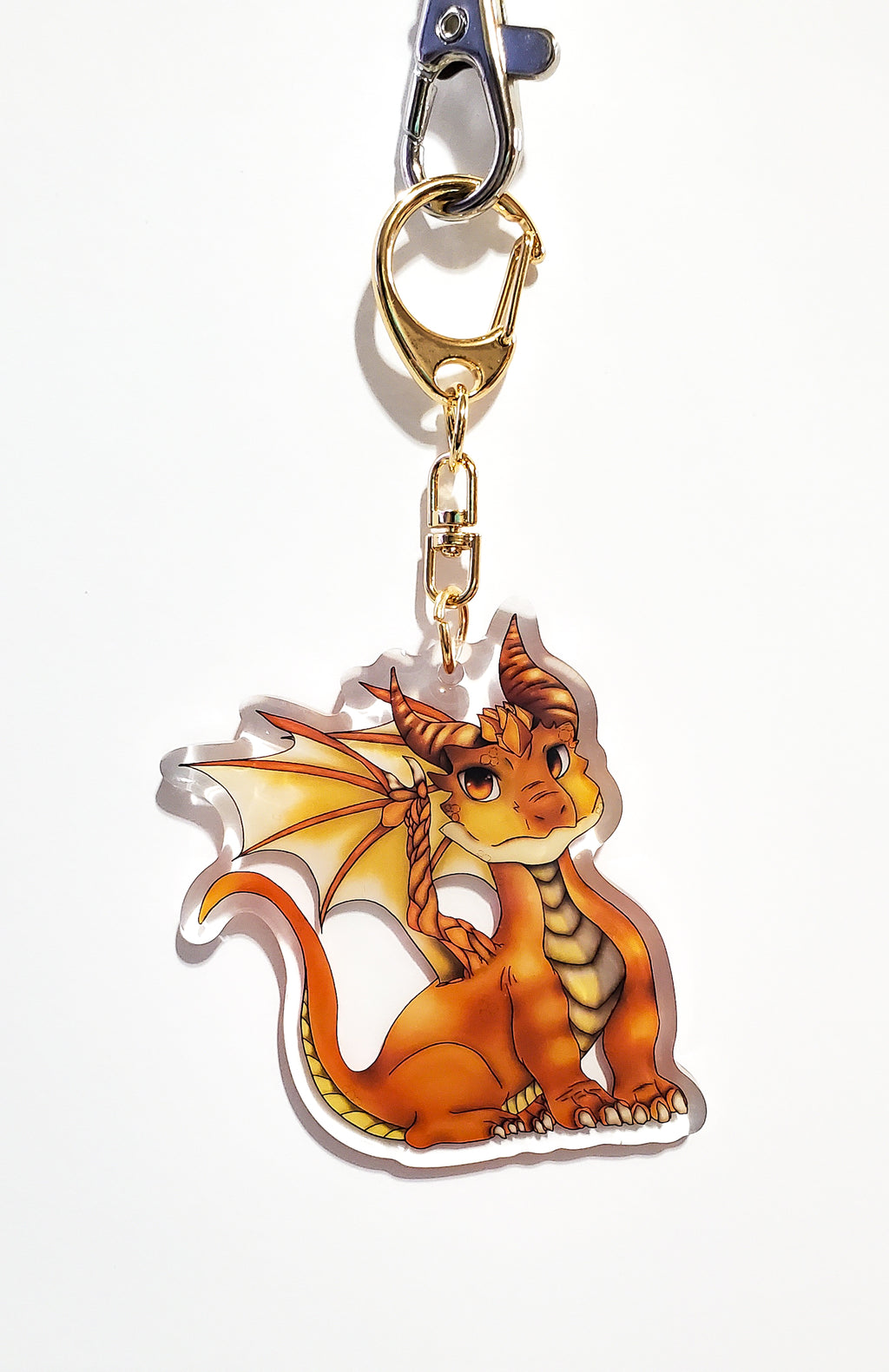Dragon-shaped keychain with a gold clip on a white background