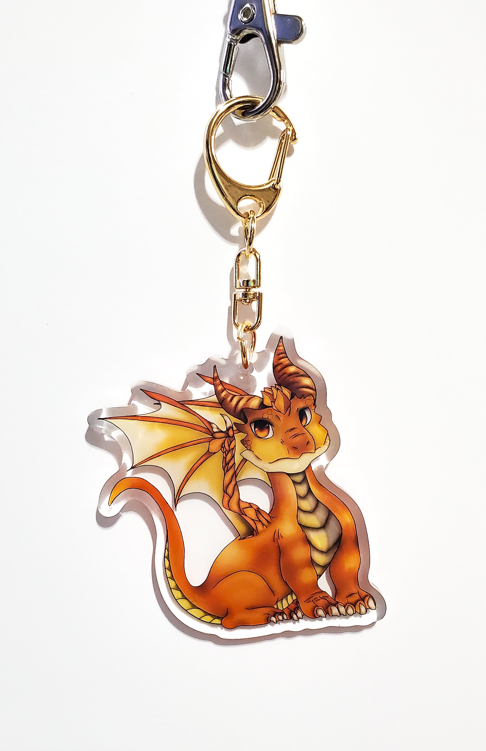 Dragon-shaped keychain with a gold clip on a white background